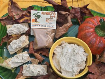 Package of Kimo's Pumpkin Spice Spread on a field of crackers and prepared ramekin or prepared Pumpkin Spice Spread.